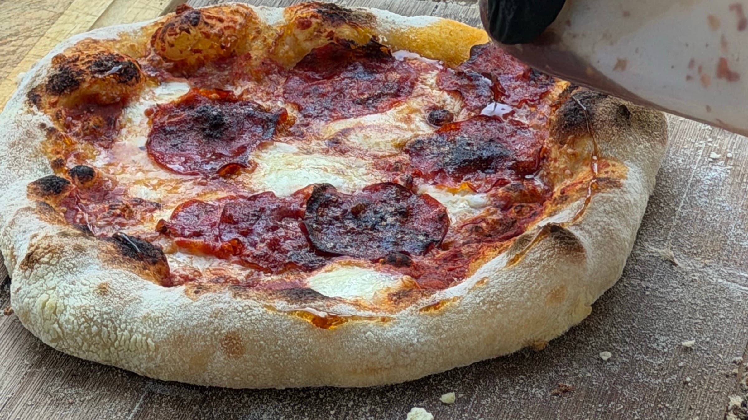 Frisch gebackene Salami-Pizza auf einem Holzbrett beim Event-Catering