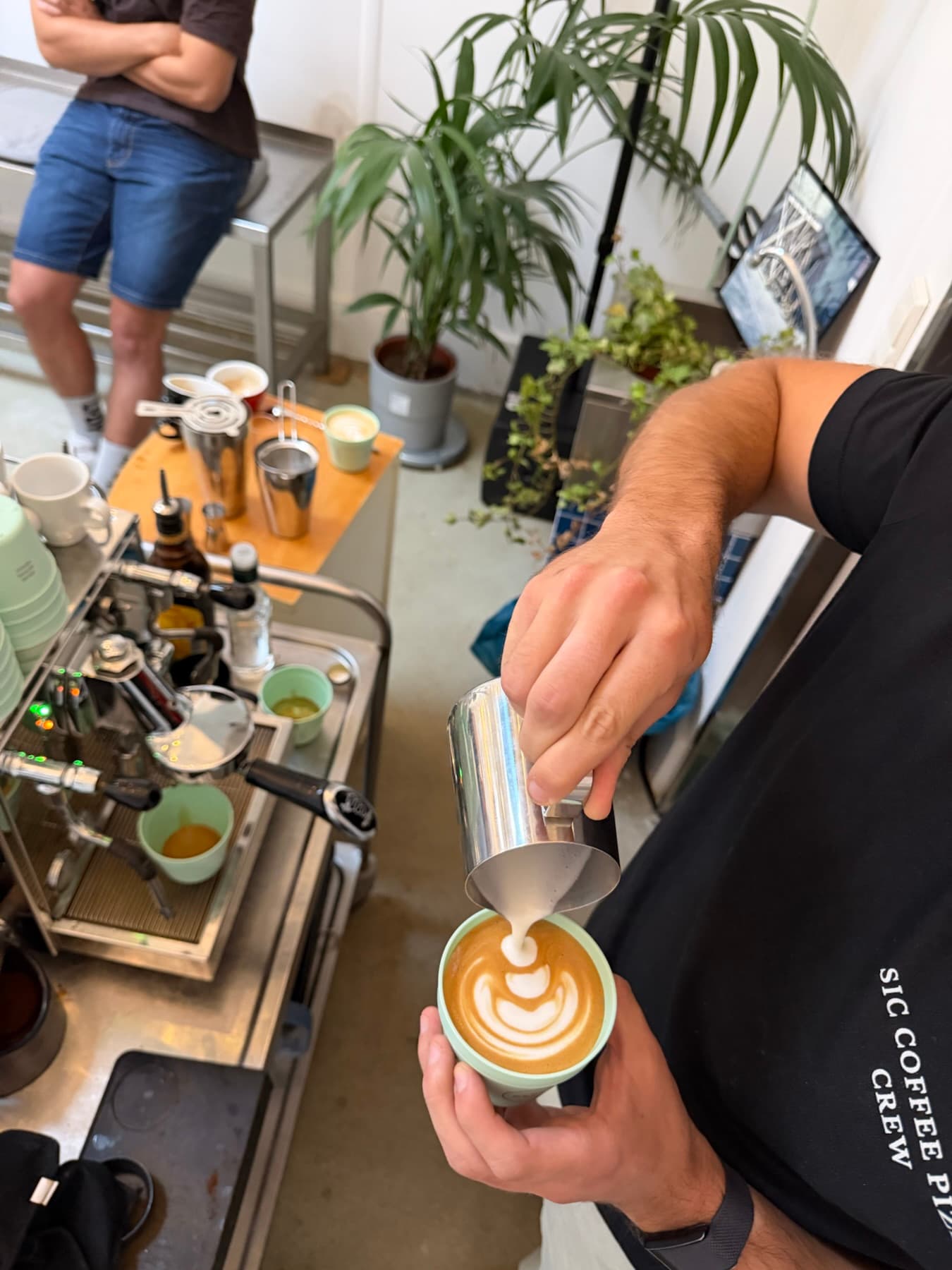 Barista gießt Latte Art an der mobilen Siebträgermaschine