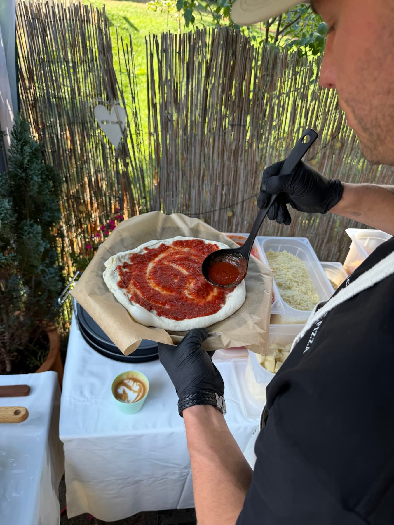 Tomatensauce wird auf einem Pizzateig verteilt