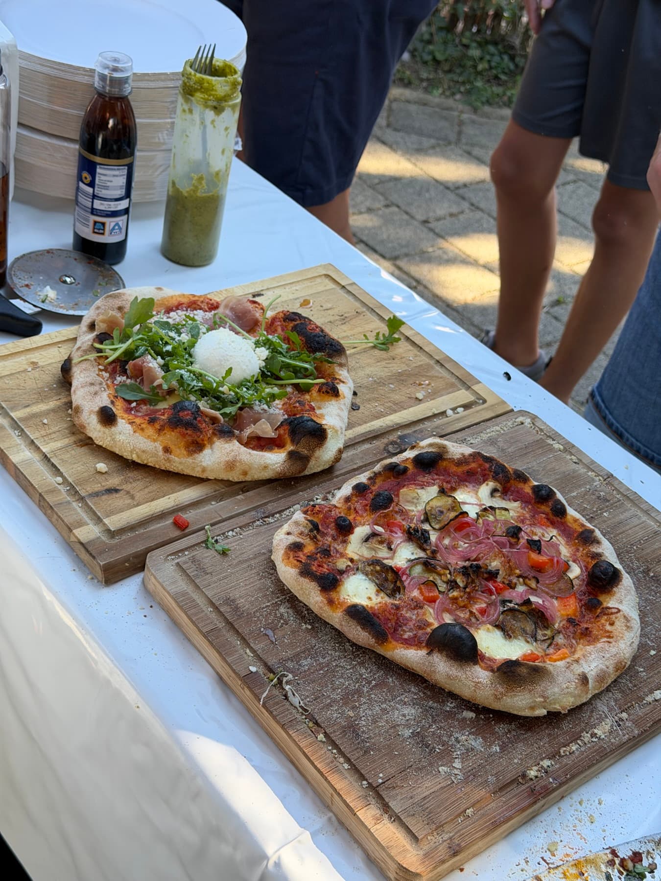 Zwei frisch gebackene Pizzen auf Holzbrettern